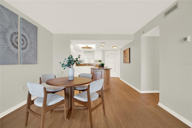 9 Haig Pl Unit 510, Dunedin, FL 34698 - dining space featuring baseboards, visible vents, and light wood-style flooring