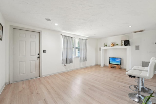 living room featuring baseboards, wood finished floors, visible vents, and recessed lighting
