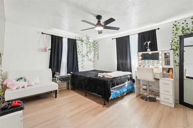 bedroom with a ceiling fan and light wood-style floors