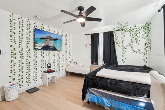 bedroom with visible vents, baseboards, wood finished floors, and ceiling fan