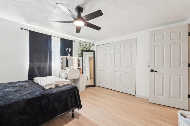 bedroom with light wood-style floors, a closet, and ceiling fan