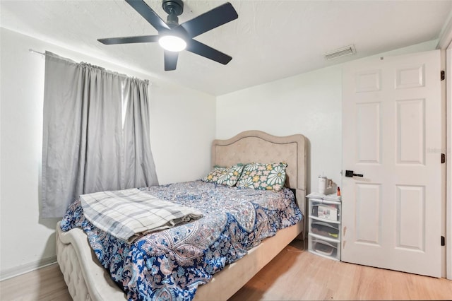 bedroom featuring a ceiling fan, wood finished floors, and visible vents