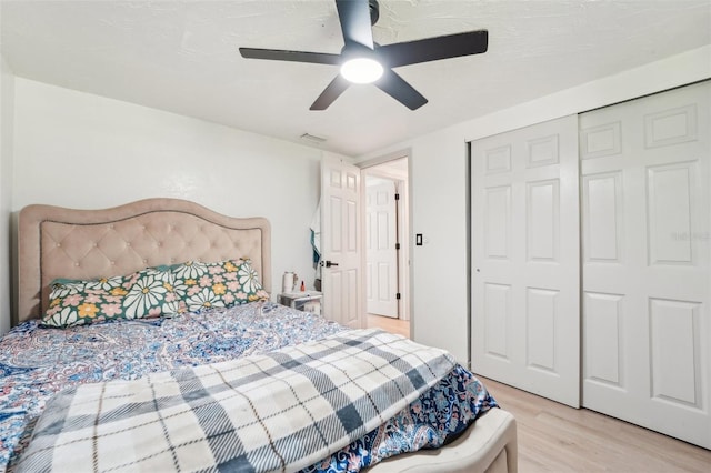 bedroom with light wood-style floors, a closet, ceiling fan, and visible vents