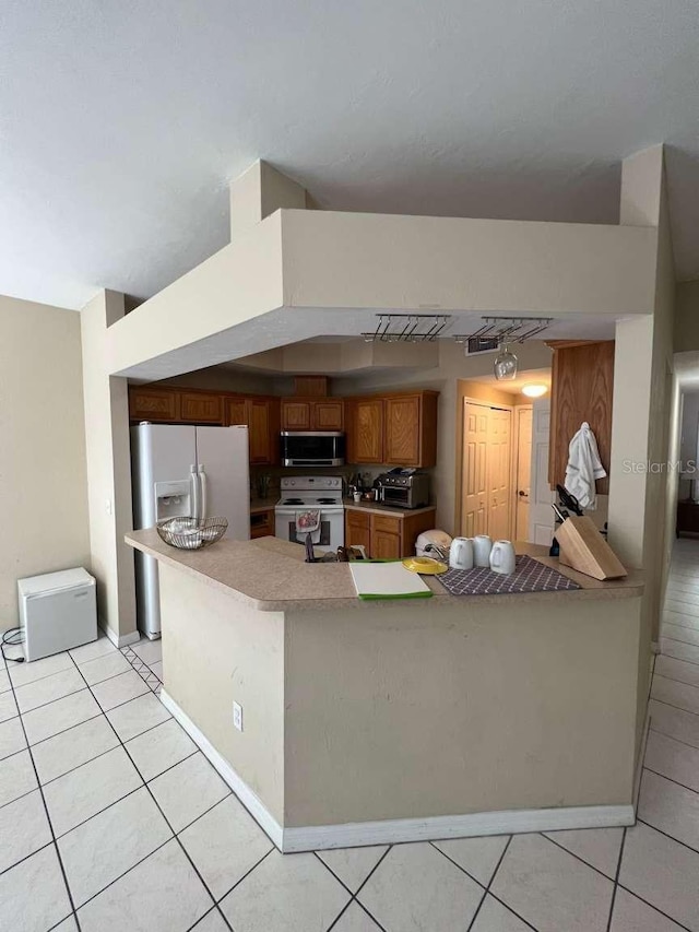 554 NW 50th Blvd, Gainesville, FL 32607 - kitchen featuring white electric range, a peninsula, stainless steel microwave, and light tile patterned flooring