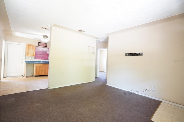 spare room featuring visible vents, a ceiling fan, baseboards, and a sink