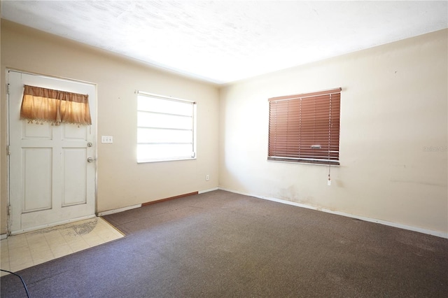 carpeted foyer entrance featuring baseboards