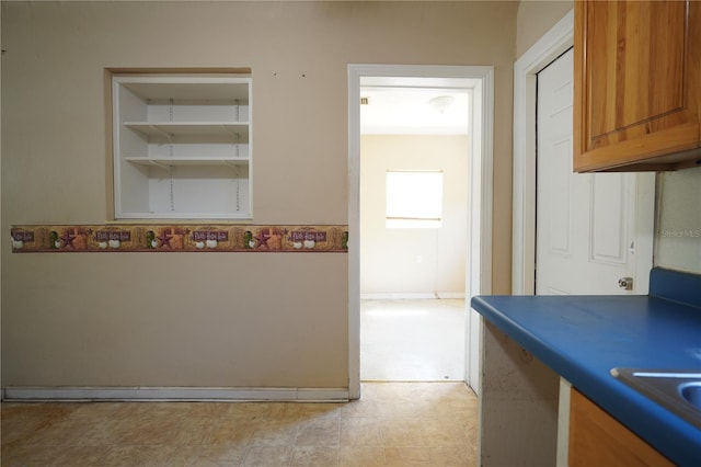 kitchen with light floors, brown cabinets, and a sink