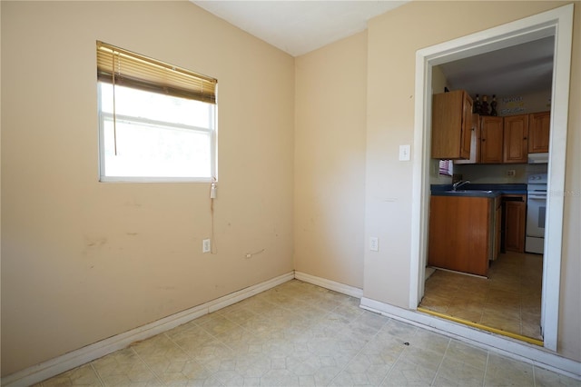 empty room with baseboards and a sink