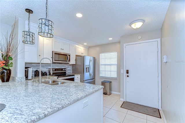 13870 Oakwood Ln Unit 13870, Seminole, FL 33776 - kitchen with a sink, light tile patterned flooring, stainless steel appliances, baseboards, and white cabinetry