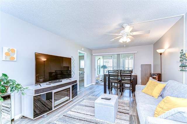 13870 Oakwood Ln Unit 13870, Seminole, FL 33776 - living room with ceiling fan, baseboards, wood finished floors, and a textured ceiling
