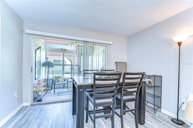 13870 Oakwood Ln Unit 13870, Seminole, FL 33776 - dining area with baseboards, a textured ceiling, and light wood-style floors