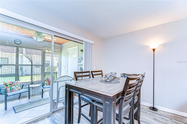 13870 Oakwood Ln Unit 13870, Seminole, FL 33776 - dining room with baseboards, a ceiling fan, a textured ceiling, and light wood-type flooring