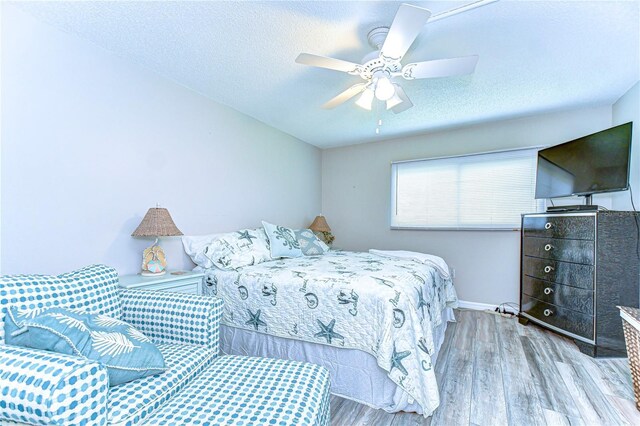 13870 Oakwood Ln Unit 13870, Seminole, FL 33776 - bedroom featuring wood finished floors, a textured ceiling, baseboards, and ceiling fan