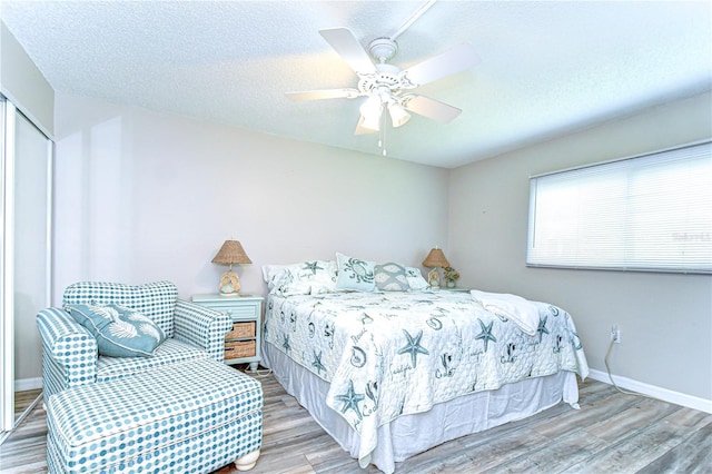 13870 Oakwood Ln Unit 13870, Seminole, FL 33776 - bedroom with a ceiling fan, wood finished floors, a textured ceiling, a closet, and baseboards