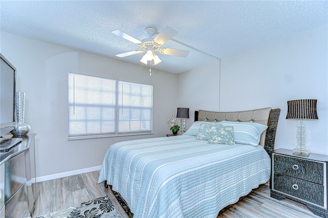 13870 Oakwood Ln Unit 13870, Seminole, FL 33776 - bedroom with wood finished floors, a textured ceiling, baseboards, and ceiling fan