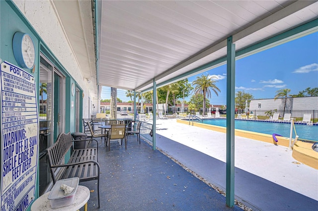 13870 Oakwood Ln Unit 13870, Seminole, FL 33776 - view of patio / terrace with a community pool, outdoor dining area, and fence