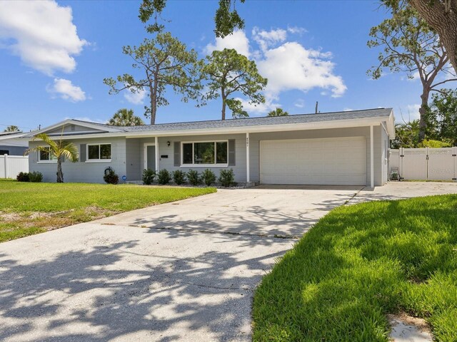 ranch-style home with concrete driveway, a front lawn, fence, and an attached garage