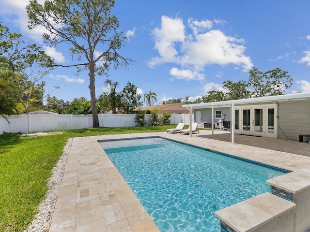 view of swimming pool with a patio area, a lawn, french doors, a fenced backyard, and a fenced in pool