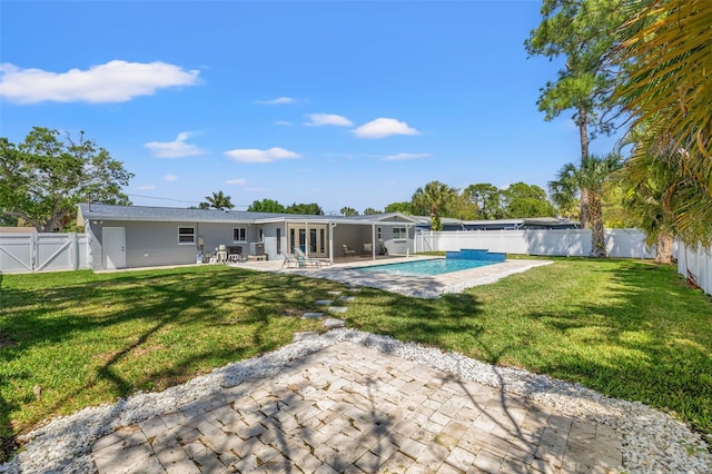 rear view of property with a lawn, a patio area, a fenced backyard, and french doors