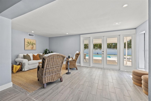 living area featuring recessed lighting, wood tiled floor, visible vents, french doors, and baseboards