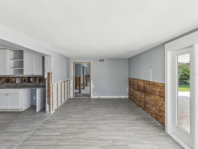 interior space featuring wood tiled floor, visible vents, and a textured ceiling