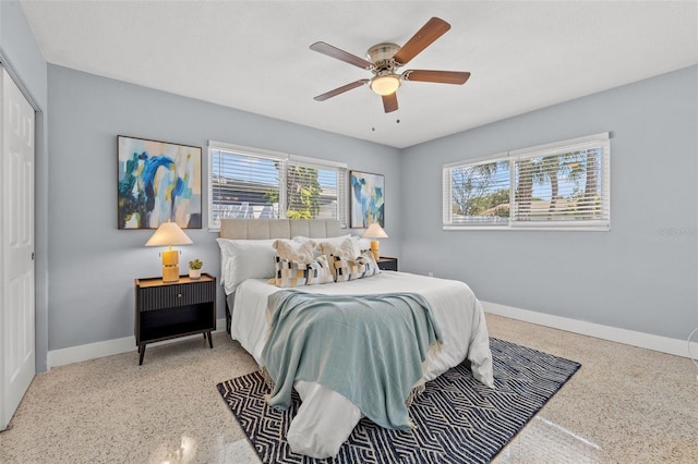 bedroom with speckled floor, ceiling fan, baseboards, and a closet