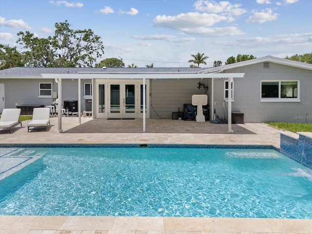 rear view of property featuring an outdoor pool, french doors, and a patio
