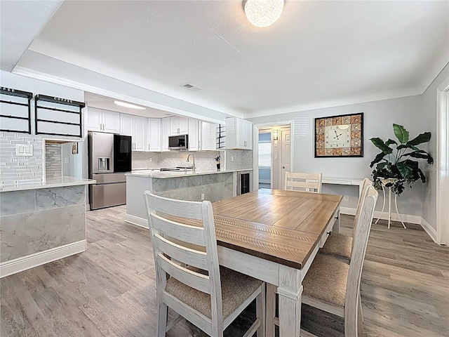 6609 Dartmouth Ave N, Saint Petersburg, FL 33710 - dining room with light wood-type flooring, visible vents, and baseboards