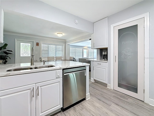 6609 Dartmouth Ave N, Saint Petersburg, FL 33710 - kitchen featuring a sink, dishwasher, light wood finished floors, white cabinets, and light stone countertops