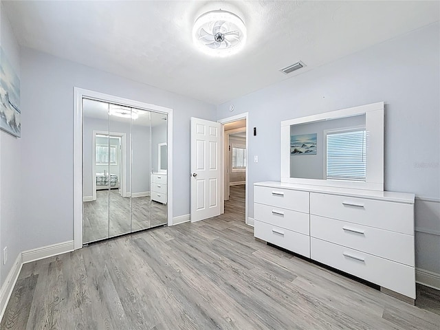 6609 Dartmouth Ave N, Saint Petersburg, FL 33710 - unfurnished bedroom with light wood finished floors, baseboards, visible vents, and a closet
