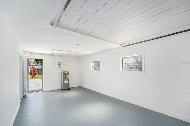 garage featuring electric water heater and baseboards