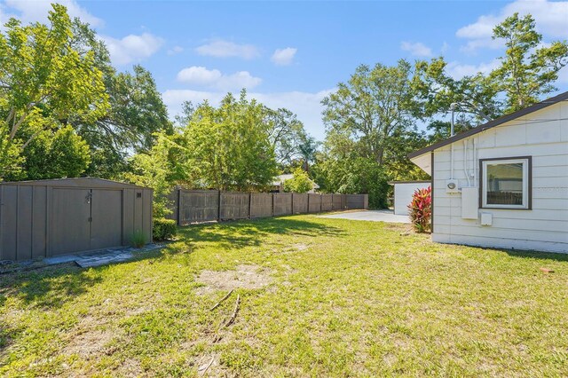 view of yard featuring a shed, an outbuilding, and a patio area
