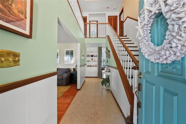 19254 Blount Rd, Lutz, FL 33558 - entrance foyer with stairs, light tile patterned floors, a high ceiling, and a wainscoted wall