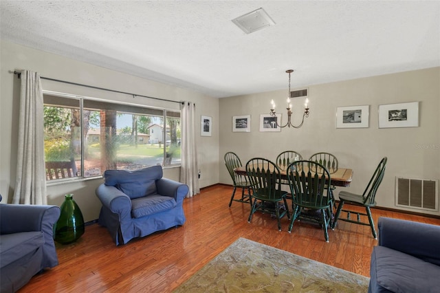 19254 Blount Rd, Lutz, FL 33558 - dining space featuring a chandelier, wood finished floors, a textured ceiling, and baseboards