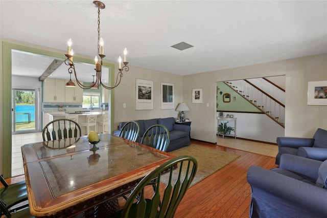 19254 Blount Rd, Lutz, FL 33558 - dining area with stairway, light wood-style flooring, and a chandelier