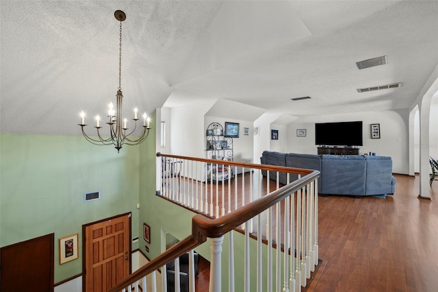 19254 Blount Rd, Lutz, FL 33558 - hallway featuring a textured ceiling, a chandelier, an upstairs landing, dark wood-type flooring, and lofted ceiling