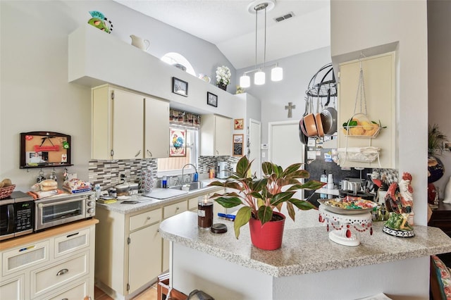 1511 Woonsocket Ln, Brandon, FL 33511 - kitchen with light countertops, backsplash, cream cabinets, a sink, and high vaulted ceiling