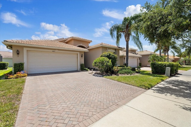 16055 Golden Lakes Dr, Wimauma, FL 33598 - view of front of property with an attached garage, a tiled roof, stucco siding, and decorative driveway