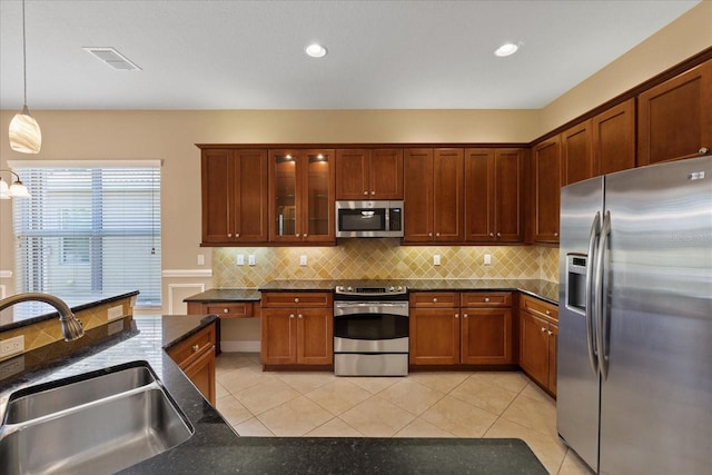 16055 Golden Lakes Dr, Wimauma, FL 33598 - kitchen featuring a sink, tasteful backsplash, appliances with stainless steel finishes, decorative light fixtures, and light tile patterned floors