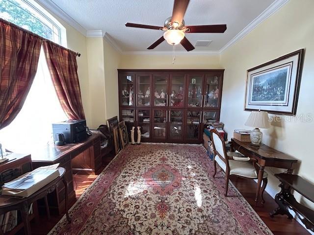 17127 Brown Rd, Odessa, FL 33556 - entrance foyer featuring wood finished floors, ceiling fan, ornamental molding, and a wood stove