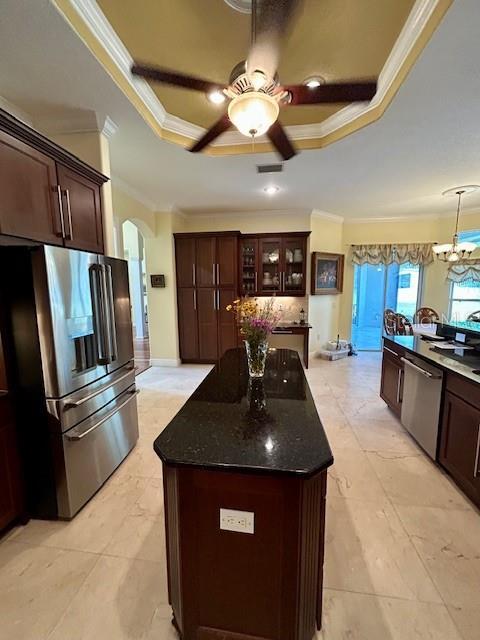 17127 Brown Rd, Odessa, FL 33556 - kitchen with stainless steel appliances, a tray ceiling, crown molding, ceiling fan, and dark stone counters