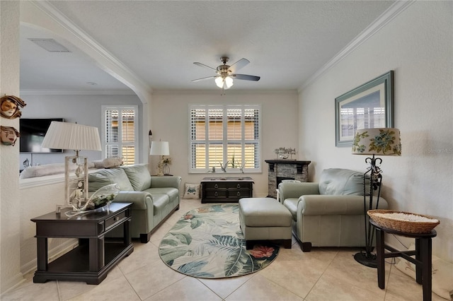 living area featuring ceiling fan, visible vents, ornamental molding, and tile patterned flooring