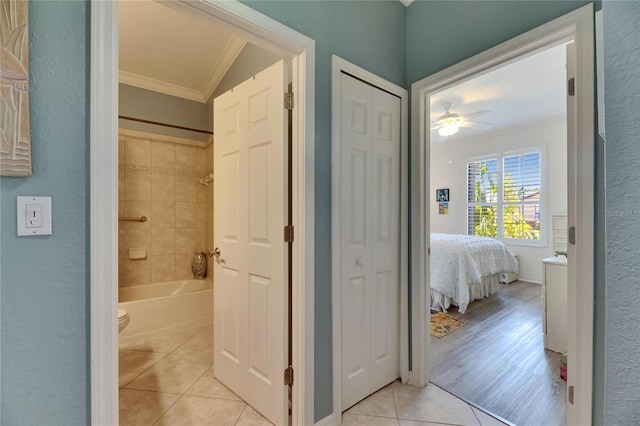 bathroom with a closet, ornamental molding, ceiling fan, tile patterned floors, and  shower combination