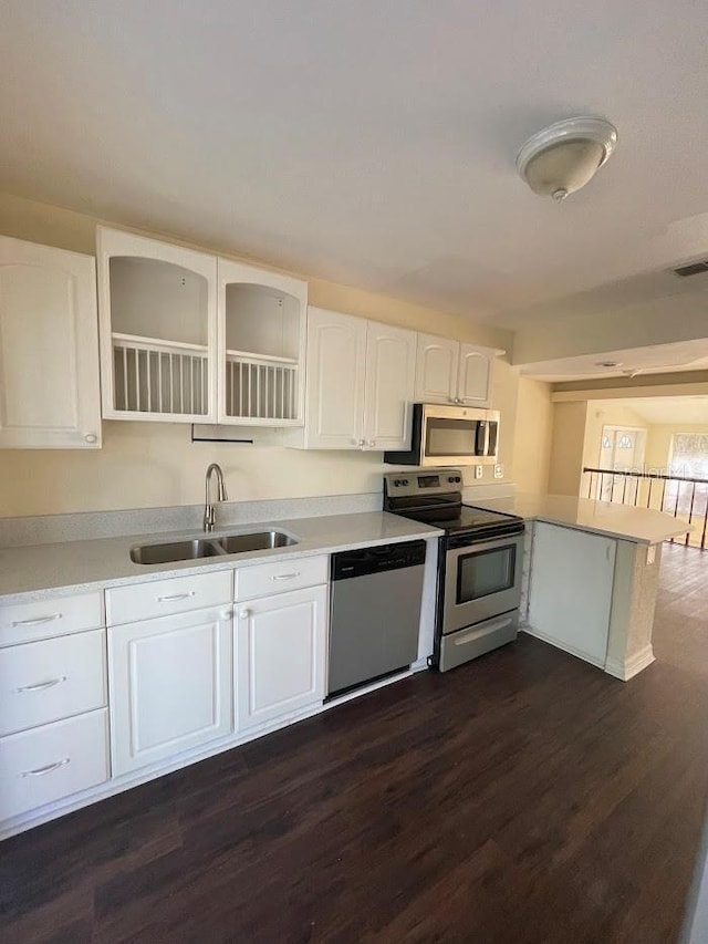 321 David Ave, Clearwater, FL 33759 - kitchen with white cabinets, light countertops, a sink, a peninsula, and appliances with stainless steel finishes