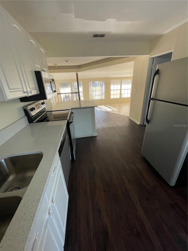 321 David Ave, Clearwater, FL 33759 - kitchen featuring white cabinets, dark wood-type flooring, freestanding refrigerator, a peninsula, and stainless steel electric range oven