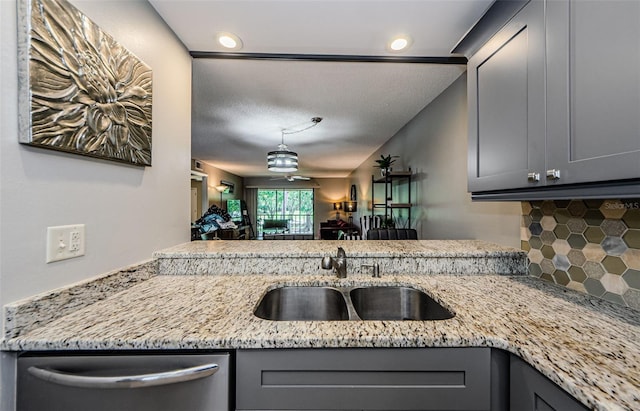 124 Nina Way Unit 24, Oldsmar, FL 34677 - kitchen featuring stainless steel dishwasher, a sink, gray cabinetry, decorative backsplash, and light stone counters
