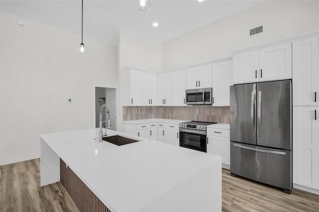 1135 Wyndham Lakes Dr, Odessa, FL 33556 - kitchen with a sink, white cabinets, stainless steel appliances, backsplash, and visible vents