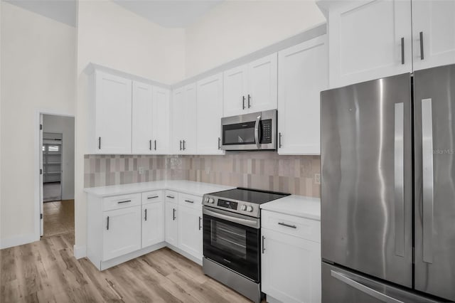 1135 Wyndham Lakes Dr, Odessa, FL 33556 - kitchen with light countertops, white cabinetry, backsplash, and appliances with stainless steel finishes