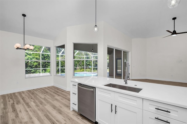 1135 Wyndham Lakes Dr, Odessa, FL 33556 - kitchen with white cabinets, stainless steel dishwasher, a sink, light wood-style floors, and light countertops