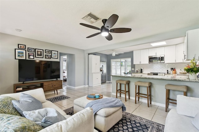 1751 Ashton Abbey Rd, Clearwater, FL 33755 - living room with light tile patterned floors and a ceiling fan